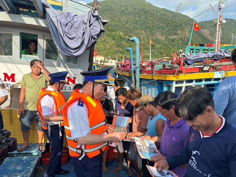 Lực lượng Cảnh sát biển Việt Nam phát tờ rơi tuyên truyền về phòng, chống khai thác IUU cho bà con ngư dân (Ảnh: dangcongsan.vn)
