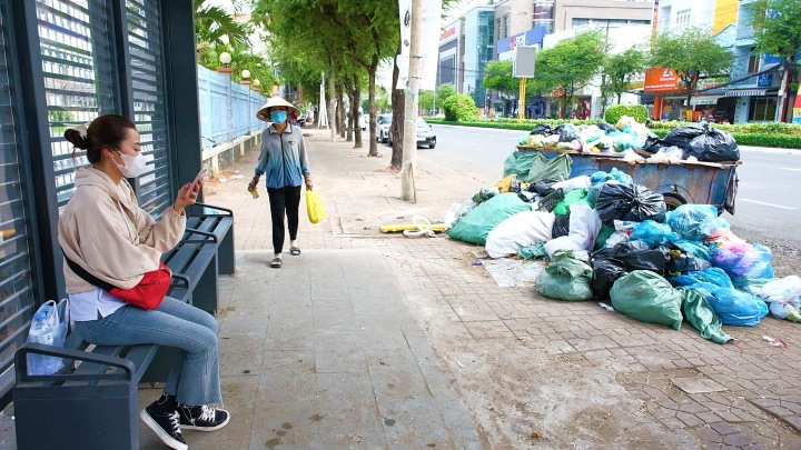 Một điểm tập kết rác nằm gần nhà chờ xe buýt