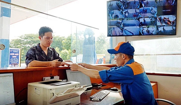 Nhân viên cửa hàng Petrolimex xuất hóa đơn giấy từ hệ thống hóa đơn điện tử cho khách hàng tại cửa hàng xăng dầu ở Hà Nội (Ảnh: N.KH/Tuổi trẻ)