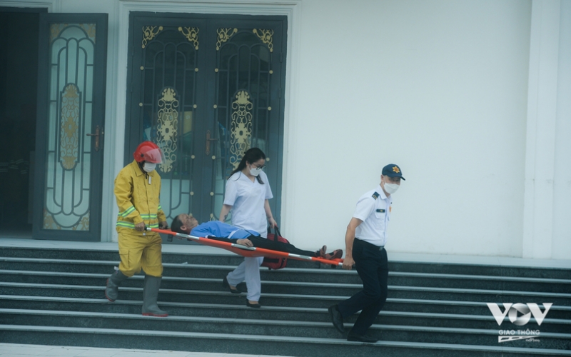 Người dân, cùng lực lượng y tế phối hợp đưa người bị nạn ở tầng 1 ra ngoài.