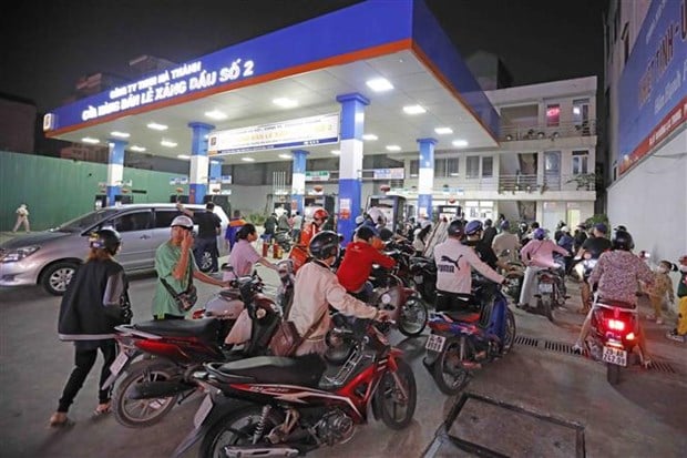 Người dân xếp hàng dài chờ mua xăng, dầu tại cửa hàng kinh doanh xăng, dầu trên phố Lạc Trung (Hà Nội), tối 5/11/2022 (Ảnh: TTXVN)