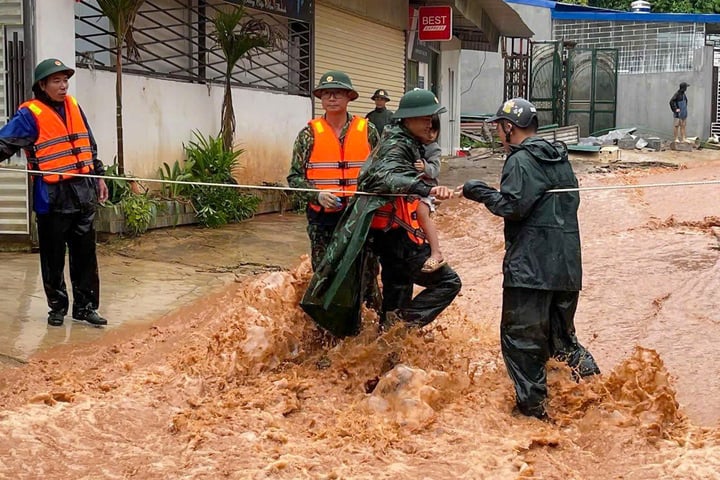 Lực lượng chức năng đưa người dân ra khỏi vùng nguy hiểm (Ảnh: VGP)