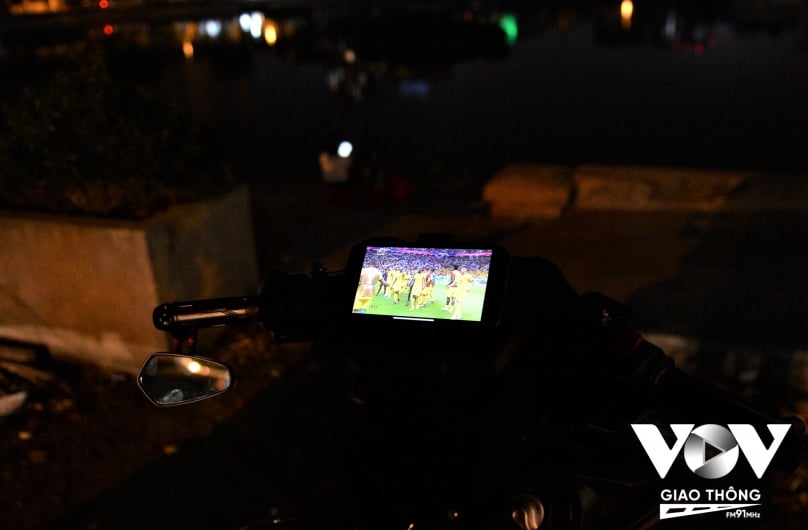 Thời điểm trận đấu đầu tiên của World Cup 2022 diễn ra trùng với thời điểm nhân viên giao đồ ăn đêm như Hoàng bận rộn nhất. Cách Hoàng chọn để xem là ngay trên chiếc điện thoại được gắn trên xe máy của mình.
