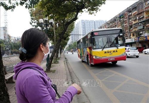 Hành khách đeo khẩu trang đợi xe buýt để phòng chống dịch COVDID-19. Ảnh: Danh Lam-TTXVN